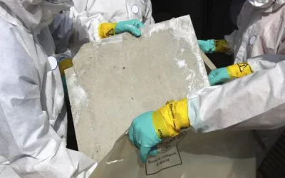 3 men in hazmat suits removing asbestos